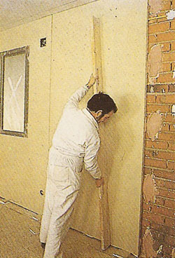 Instalador nivelando un panel de pladur